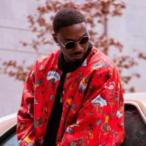 Person wearing a bright red patterned streetwear jacket with graphic prints.