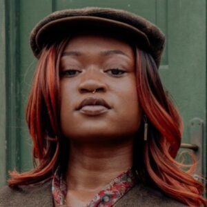 Person wearing a brown newsboy-style hat with casual streetwear outfit.