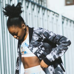Black-and-white patterned sports jacket worn over a sports bra.