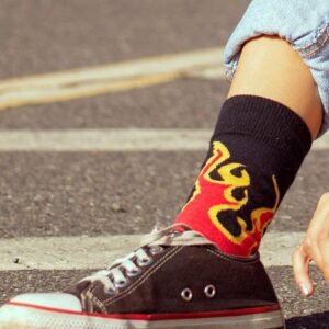 A pair of unisex streetwear sneakers in dark tones, styled for casual urban wear on pavement.