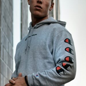 Gray hoodie with red sleeve cutouts, worn in an urban street setting.